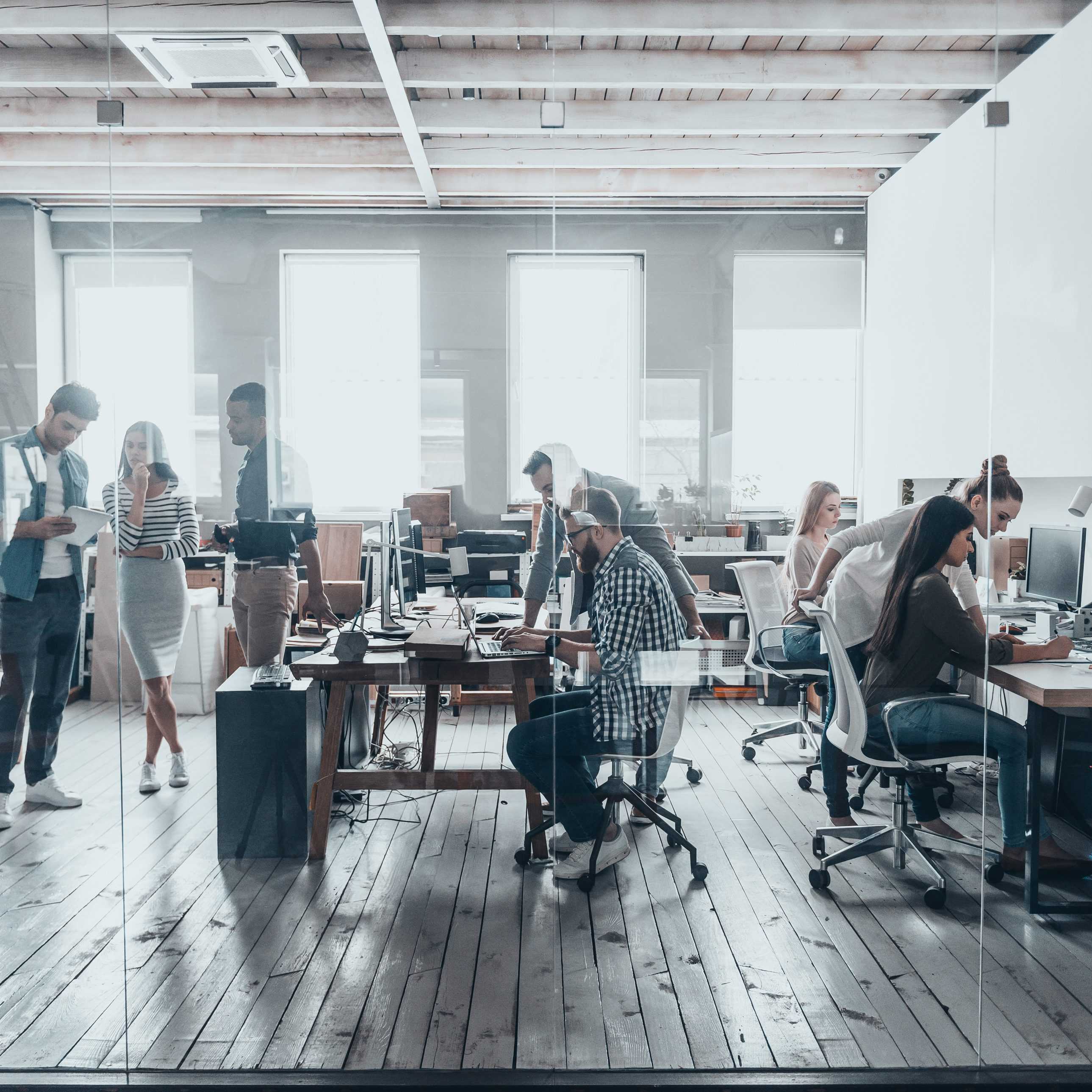 Group of young business people in smart casual wear working together in creative office